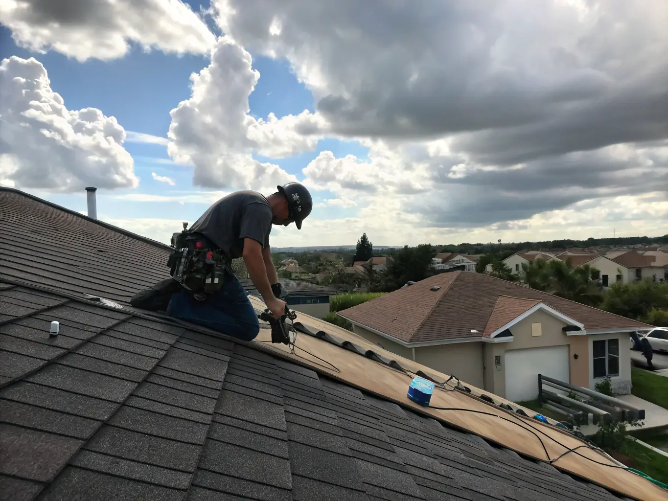 A high-angle, close-up shot of a Blue Raider Roofing crew member expertly installing shingles on a residential roof, showcasing their attention to detail and precision.